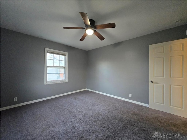 carpeted spare room featuring ceiling fan