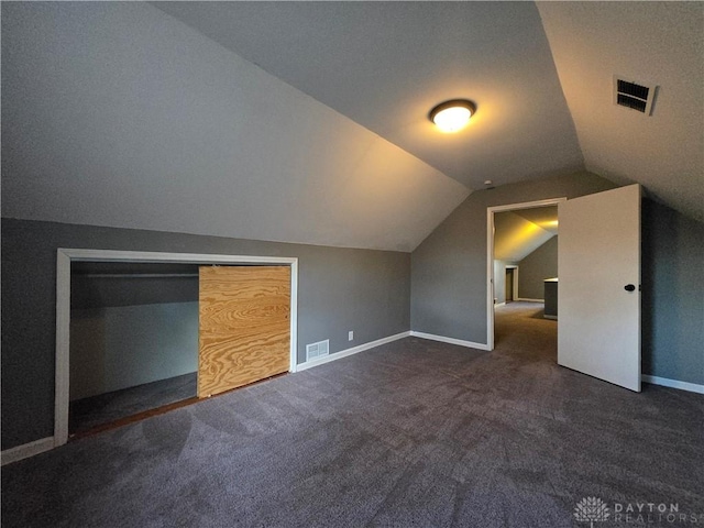 bonus room featuring lofted ceiling and dark carpet