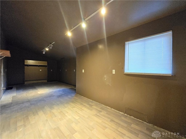 unfurnished room with lofted ceiling and light hardwood / wood-style floors