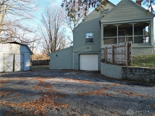 view of home's exterior with a garage and a shed