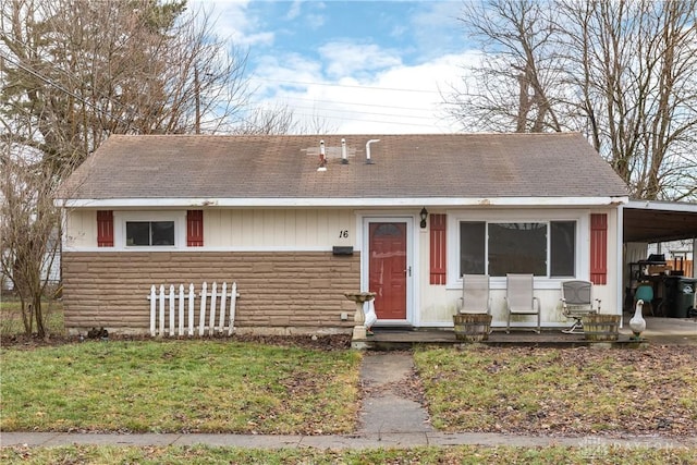 view of front facade with a carport and a front yard