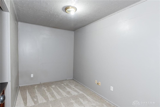 unfurnished room featuring light colored carpet and a textured ceiling