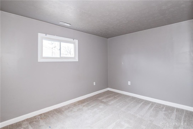 carpeted empty room featuring a textured ceiling