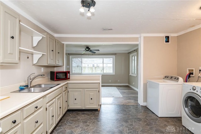 washroom with sink, crown molding, cabinets, washer and dryer, and ceiling fan