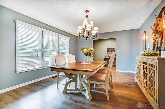 dining room featuring hardwood / wood-style flooring and a chandelier