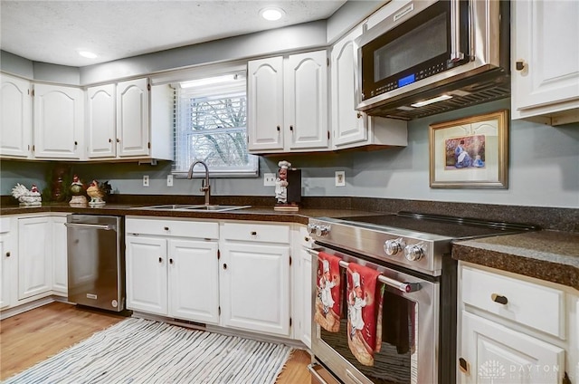 kitchen with sink, stainless steel appliances, and white cabinets