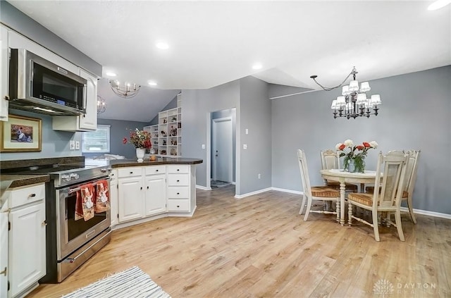 kitchen featuring stainless steel appliances, a notable chandelier, white cabinets, vaulted ceiling, and light wood-type flooring