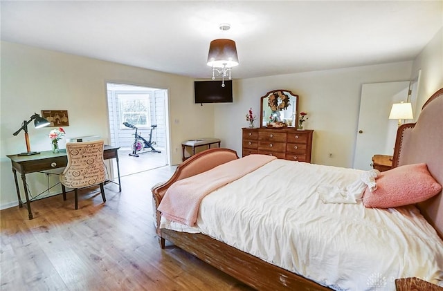 bedroom with access to exterior and light wood-type flooring