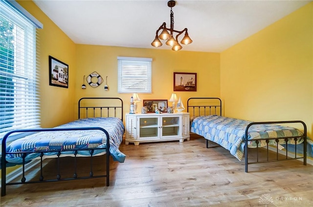 bedroom with multiple windows and light hardwood / wood-style flooring