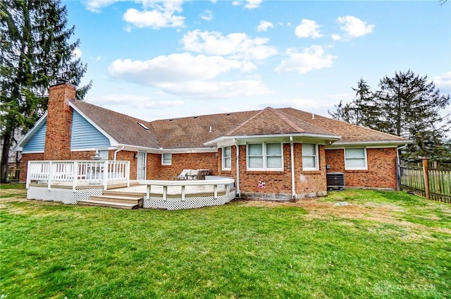 back of property with a wooden deck, central AC unit, and a lawn