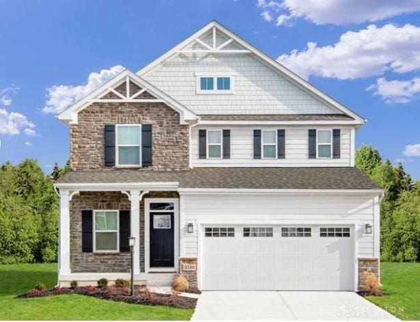 craftsman-style house featuring a garage and a front lawn