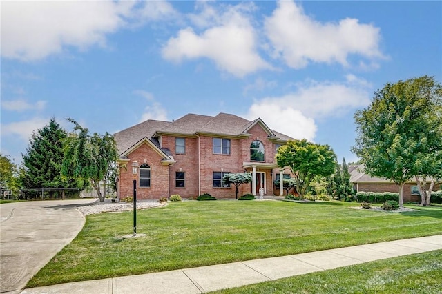 view of front of home with brick siding and a front lawn