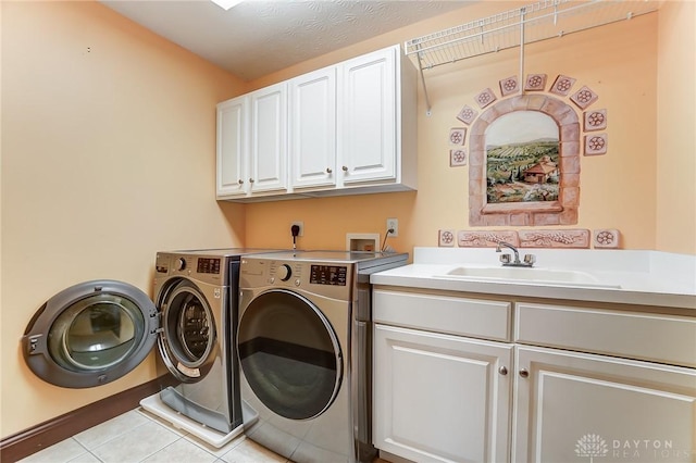 clothes washing area featuring washer and dryer, cabinet space, a sink, and light tile patterned floors