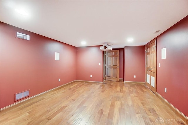 unfurnished room featuring light wood finished floors, visible vents, and baseboards