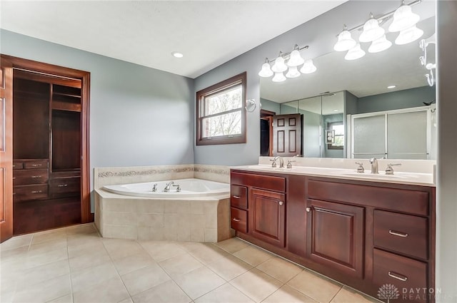 full bathroom with a garden tub, a sink, and tile patterned floors