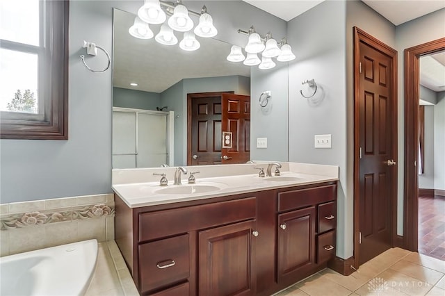 full bathroom with double vanity, a tub to relax in, tile patterned flooring, a shower stall, and a sink