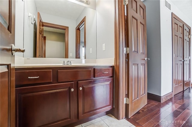 bathroom with wood finished floors, vanity, visible vents, and baseboards