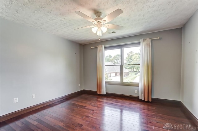 empty room with a textured ceiling, ceiling fan, dark wood-style flooring, and visible vents