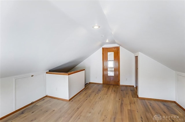 bonus room featuring lofted ceiling and light hardwood / wood-style floors