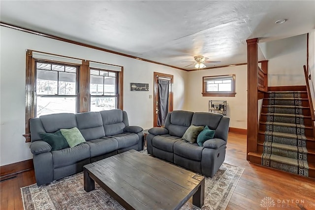 living room featuring hardwood / wood-style flooring, ornamental molding, and ceiling fan