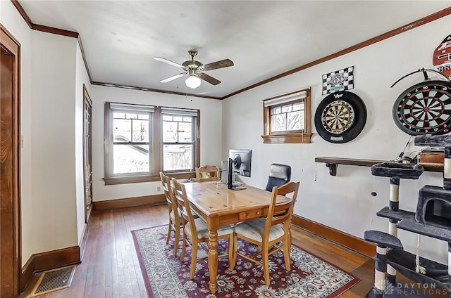 dining room with hardwood / wood-style floors, crown molding, and ceiling fan