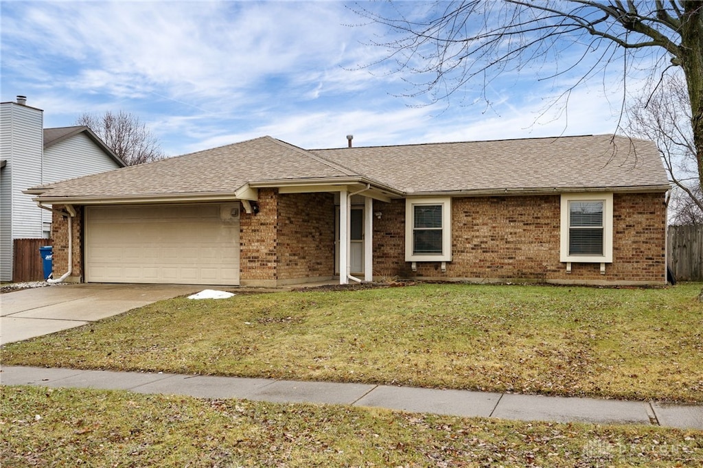 ranch-style house featuring a garage and a front lawn