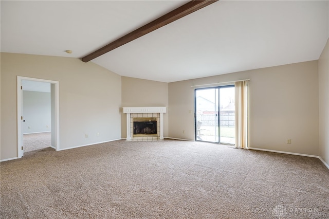 unfurnished living room with carpet flooring, a tiled fireplace, and lofted ceiling with beams