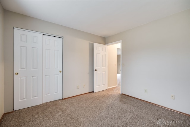 unfurnished bedroom featuring a closet and carpet flooring