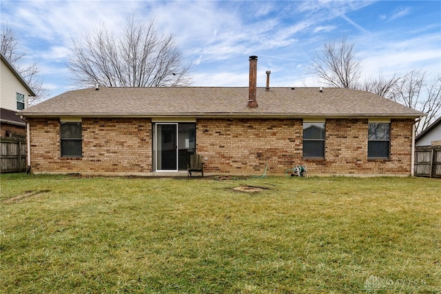 rear view of property featuring a lawn