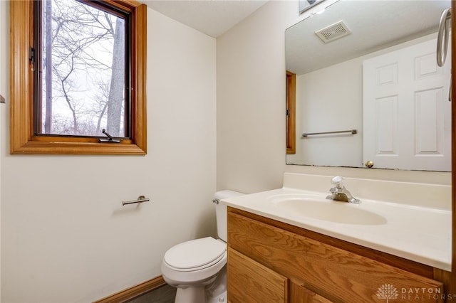 bathroom with vanity, toilet, and a wealth of natural light