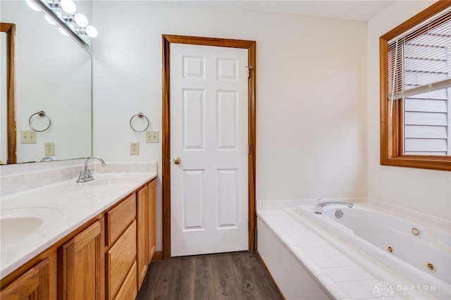 bathroom featuring vanity, wood-type flooring, and a bath