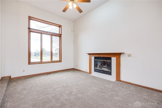 unfurnished living room with ceiling fan, carpet flooring, a fireplace, and vaulted ceiling