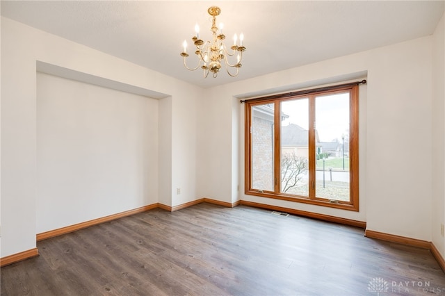 unfurnished room with hardwood / wood-style floors and a chandelier