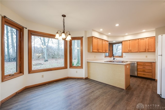 kitchen with hanging light fixtures, white refrigerator, dark hardwood / wood-style flooring, kitchen peninsula, and dishwasher