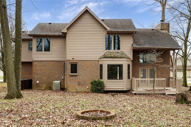 rear view of house featuring cooling unit, an outdoor fire pit, and a deck