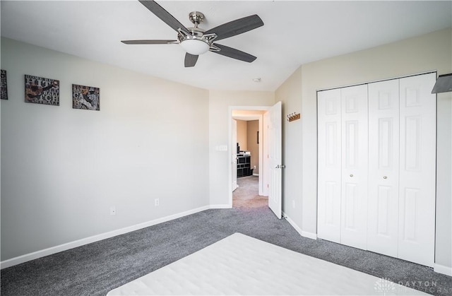 unfurnished bedroom with ceiling fan, a closet, and dark colored carpet