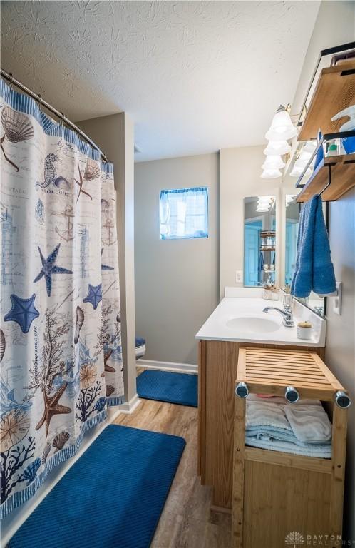 bathroom featuring vanity, hardwood / wood-style floors, and a textured ceiling