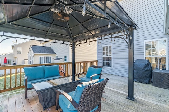 wooden deck featuring a gazebo, an outdoor hangout area, ceiling fan, and grilling area