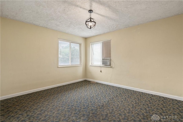 carpeted empty room with a textured ceiling