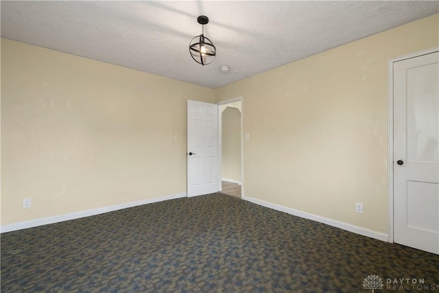 carpeted empty room with a textured ceiling