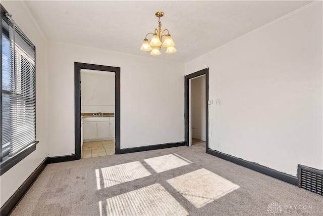 unfurnished room featuring crown molding, light colored carpet, and a chandelier