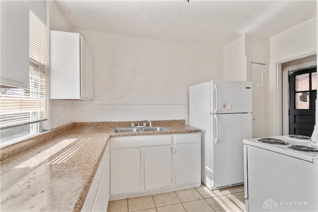 kitchen with white cabinetry, sink, light tile patterned floors, white appliances, and a textured ceiling