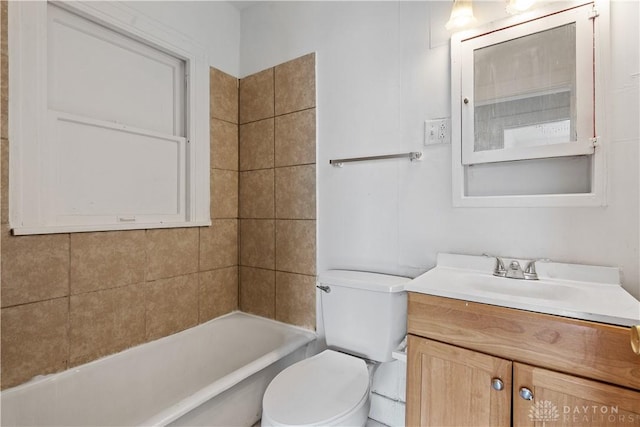 full bathroom featuring tiled shower / bath, vanity, and toilet