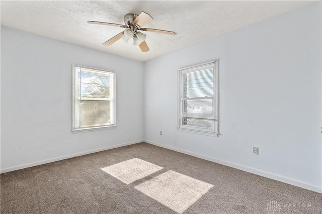 empty room featuring ceiling fan, a textured ceiling, and carpet flooring