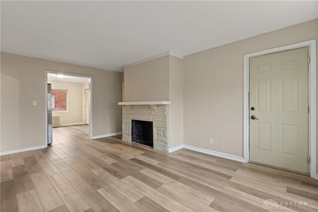 602 Rockford Ave, Dayton, OH 45405 - unfurnished living room with radiator, light wood-style floors, a fireplace, and baseboards