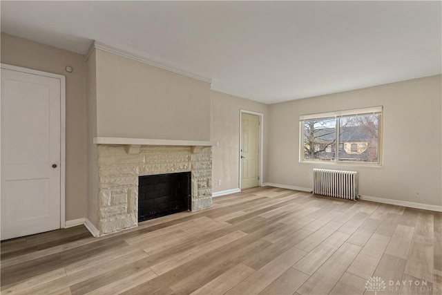602 Rockford Ave, Dayton, OH 45405 - unfurnished living room featuring a fireplace, baseboards, radiator heating unit, and light wood-style flooring