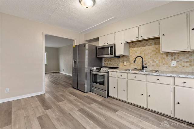 602 Rockford Ave, Dayton, OH 45405 - kitchen featuring white cabinets, decorative backsplash, stainless steel appliances, and a sink