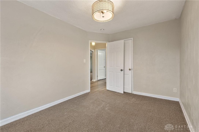 carpeted spare room with a textured ceiling