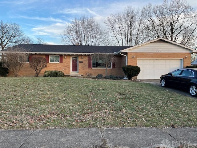 ranch-style home featuring brick siding, an attached garage, and a front lawn