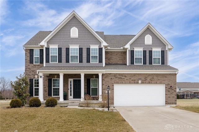 view of front of house featuring a garage, covered porch, and a front yard